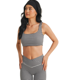 Woman wearing a black and white GINGHAM checkered tsports bra on a white backgrounD