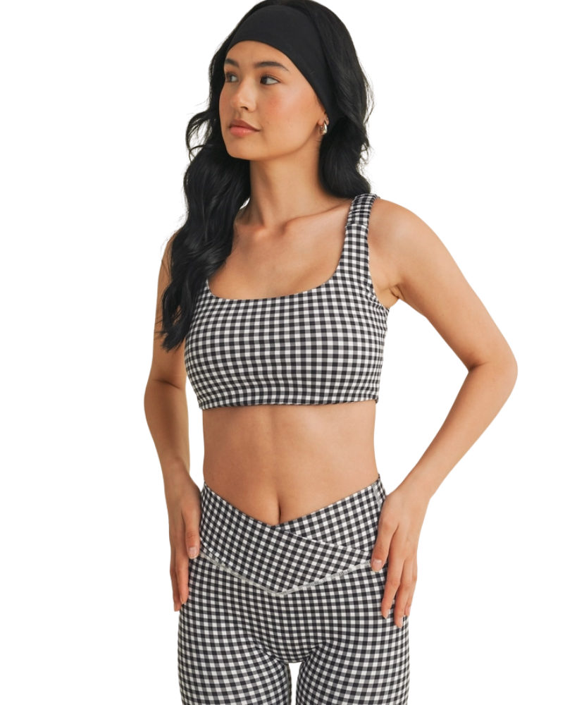 Woman wearing a black and white GINGHAM checkered tsports bra on a white backgrounD
