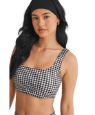 Woman wearing a black and white GINGHAM checkered tsports bra on a white backgrounD