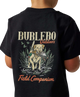 A child wearing a black short-sleeve T-shirt, shown from the back. The shirt features a large graphic print with the words 'BURLEBO Outdoors' and 'Field Companion' in orange and beige lettering, surrounding an illustration of a yellow Labrador retriever holding a fish in a marsh.