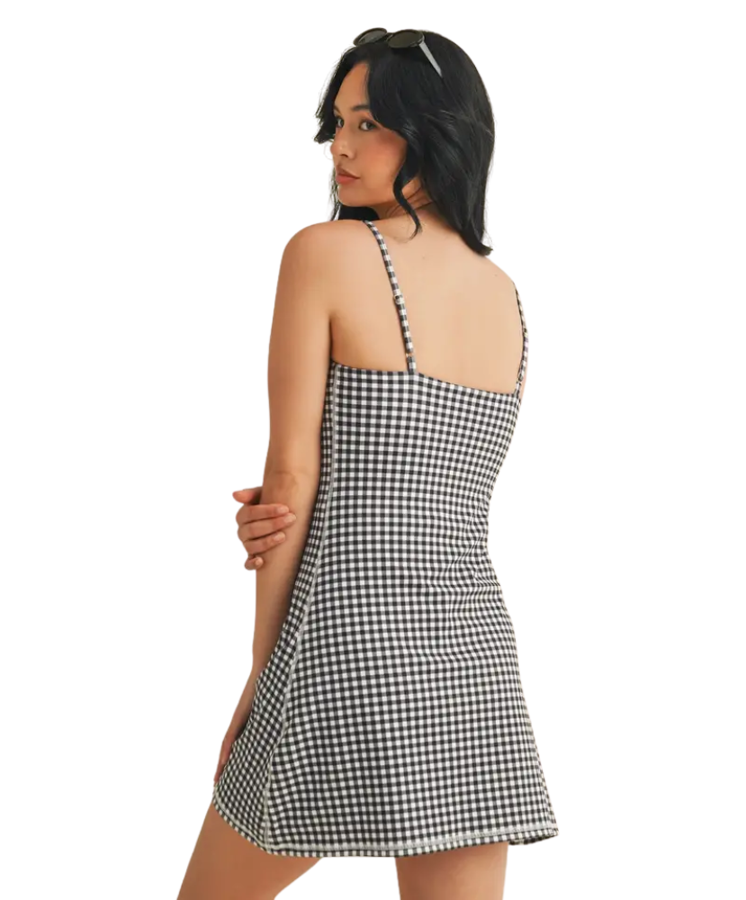 Woman wearing a black and white gingham dress on a white background
