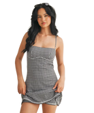 Woman wearing a black and white gingham dress on a white background