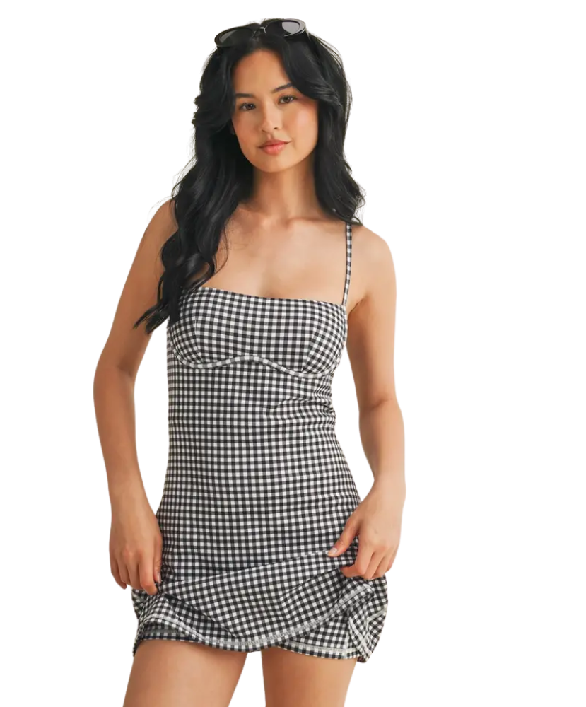 Woman wearing a black and white gingham dress on a white background