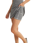 Person wearing a black and white gingham dress with a white background