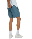 Person wearing blue shorts and white sneakers on a white background