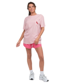Woman wearing a pink Southern Shirt Co t-shirt and shorts set on a white background