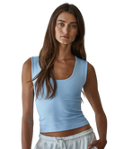 Woman wearing a light blue tank top against a white background