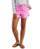 Person wearing pink HUK shorts on a white background