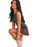 Woman wearing a brown polka dot dress on a white background