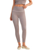 Person wearing a gingham checkered outfit with leggings and a top on a white background