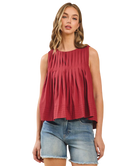 Woman wearing a burgundy sleeveless top and denim shorts on a white background