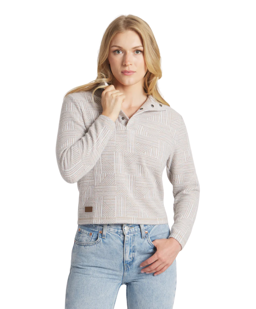 Woman wearing a light gray patterned sweater and blue jeans on a white background