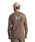 Man wearing a brown long-sleeve shirt with a duck logo on the back, standing against a white background.