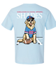A light blue short-sleeve t-shirt showing the back graphic. The graphic features a cartoon golden retriever wearing a blue and red football jersey, a matching cap, sunglasses, and sitting next to a football.