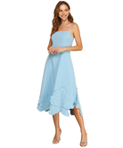 Woman wearing a light blue dress with ruffled hem on a white background