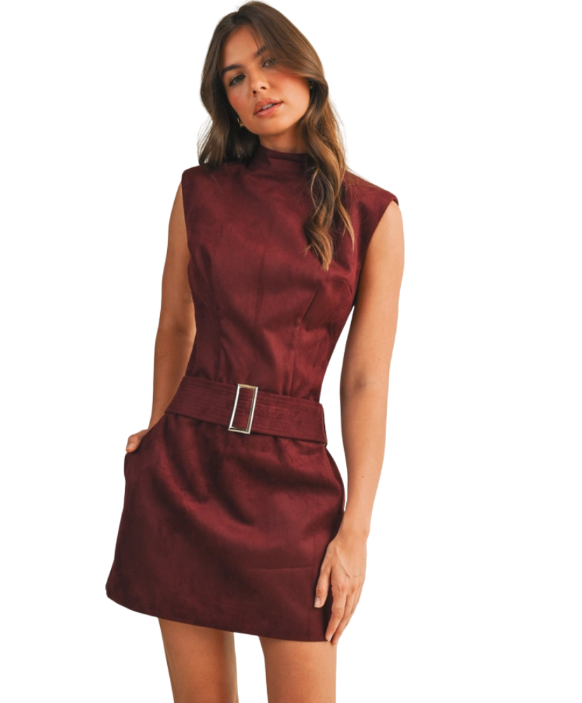 Woman wearing a maroon dress with a belt on a white background