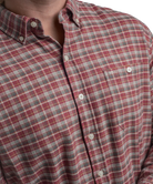 Red and gray plaid shirt with a brand logo on a white background