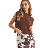 Woman wearing a brown sleeveless sweater with a patterned skirt on a white background
