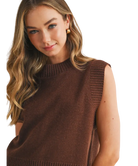 Woman wearing a brown sleeveless sweater on a white background