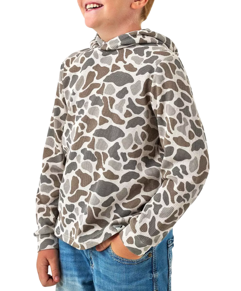 A child wearing a long-sleeve hooded top with an allover organic animal-print pattern in beige, brown, and gray, paired with blue jeans against a plain white background.