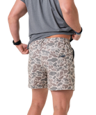 Person wearing camouflage shorts on a white background