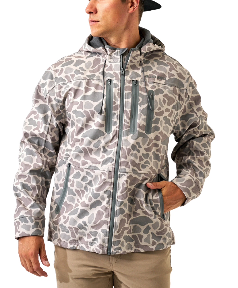 A man wearing a hooded camouflage jacket with a gray and beige pattern, paired with khaki pants, shown against a plain white background.