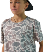Child wearing a camouflage-patterned t-shirt on a white background