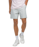 Person wearing light gray shorts, white sneakers, and a patterned shirt on a white background