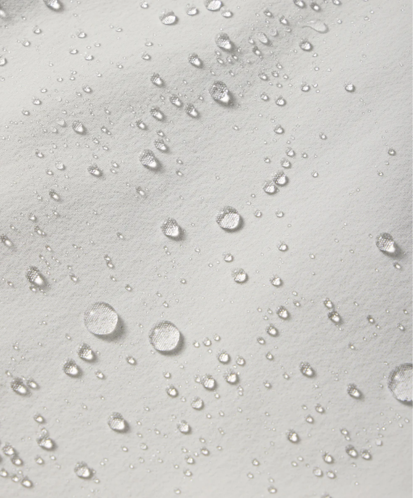 Close-up of water droplets on a shorts surface with a light gray background