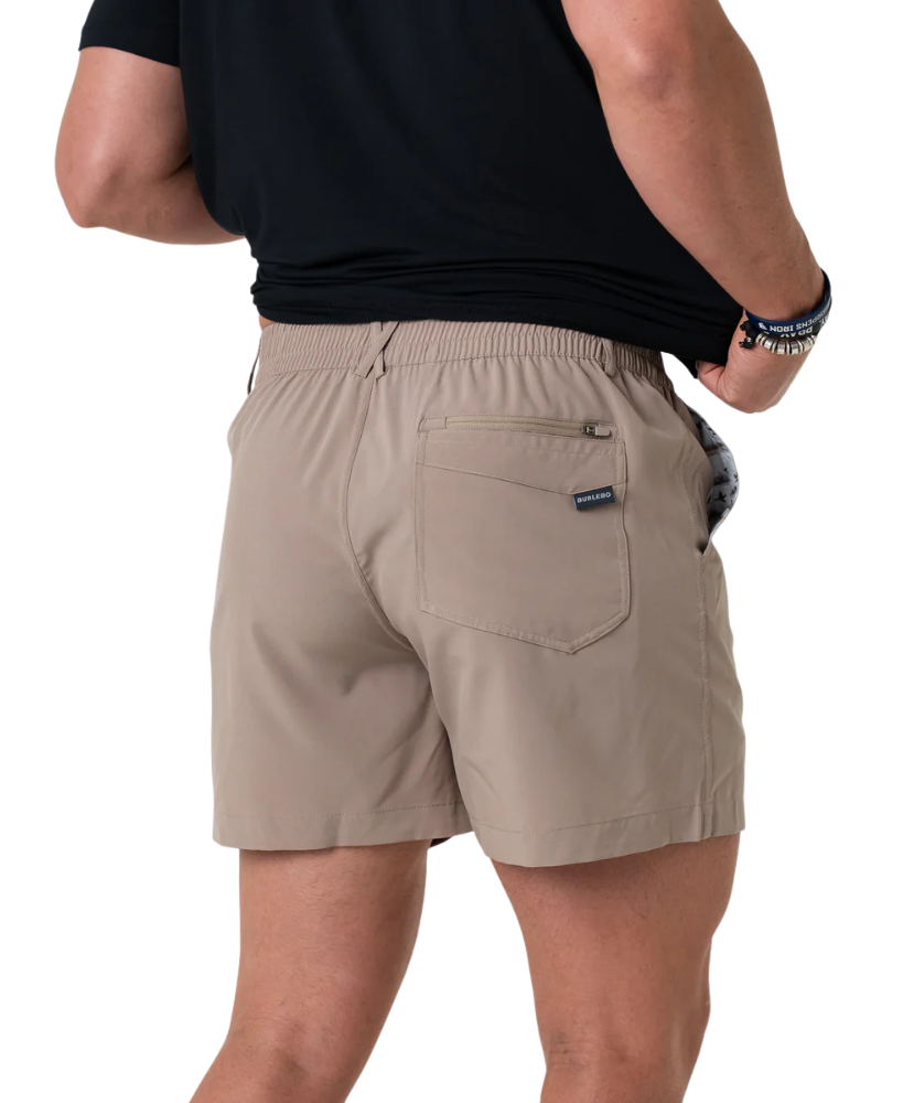 Beige shorts worn by a person on a white background