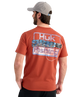Man wearing an RED Huk Fishing t-shirt with a fishing lure logo on the back against a white background