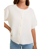 Woman wearing a white textured blouse with short sleeves on a white background
