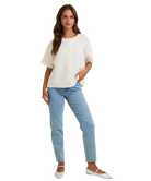 Woman wearing a white blouse and light blue jeans on a white background