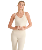Woman wearing a beige tank top and pants on a white background