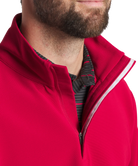 Man wearing a crimson pullover on a white background