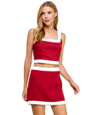 Woman wearing a red two-piece outfit with white accents on a white background