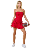 Woman in a red dress holding a football on a white background