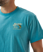 Person wearing a blue t-shirt with a largemouth bass and 'Burlebo Bait + Rigs' branding and graphics.