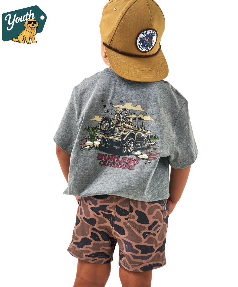 Child wearing a gray t-shirt with a JEEP graphic design and camouflage shorts, standing against a white background.