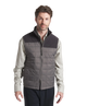 Man wearing a gray quilted vest over a light shirt on a white background