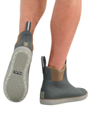 A pair of HUK ankle-height water shoes shown on a model's feet against a white background, displaying the side profile, sole tread, and heel pull tab.