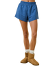 Blue shorts worn by a person with brown boots on a white background
