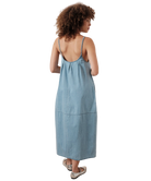Woman wearing a light blue denim dress on a white background