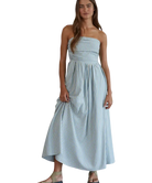 Woman wearing a light blue striped dress on a white background