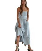 Woman wearing a light blue striped dress on a white background