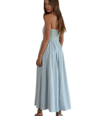 Woman wearing a light blue striped dress on a white background