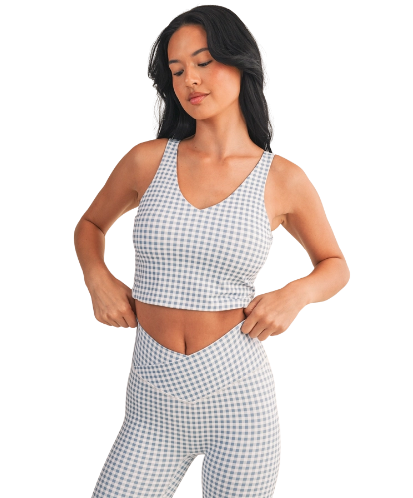 Woman wearing a light blue and white GINGHAM checkered tank on a white background