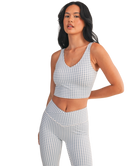 Woman wearing a light blue and white GINGHAM checkered tank on a white background