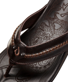 Close-up of a brown sandal with intricate design on the insole against a white background