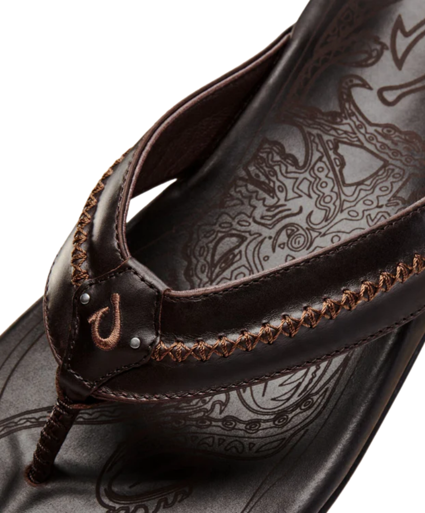 Close-up of a brown sandal with intricate design on the insole against a white background